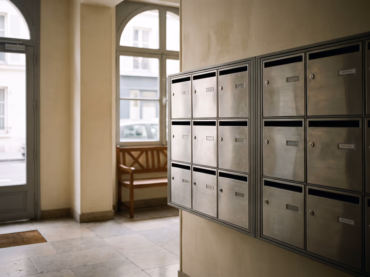 Mur de boîtes aux lettres en inox dans le hall d'un immeuble