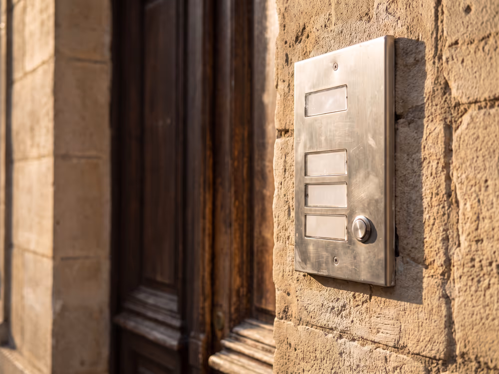 Interphone en inox sur le mur de pierre à l'entrée d'un immeuble